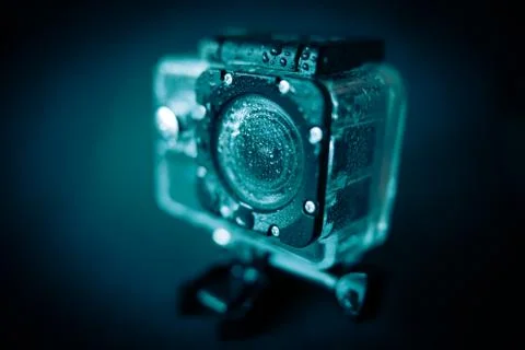 Action camera in a protective case with water drops on the case. Stock Photos