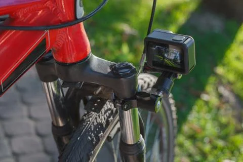 Action camera with a screen on, mounted next to a mountain bike wheel Foto stock