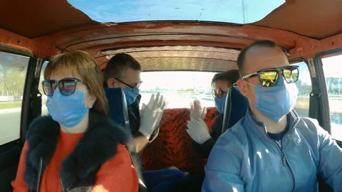 Action camera shot from inside a moving old car: a family in protective masks Stock Footage 128624626