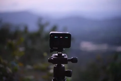 Action Camera on Tripod Capturing Mountain Landscape at Sunrise Foto stock