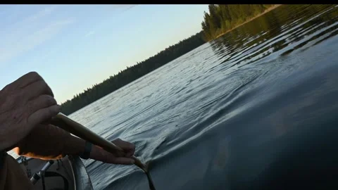 Action camera view of a person paddling a canoe on a calm lake  Stock Footage 285552832