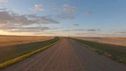 Action camera view while driving a gravel road in open farmland as the sun sets Stock Footage 287106848