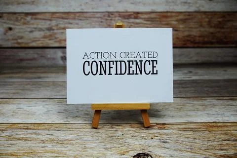 Action Created Confidence Quote text on paper card with easel on wooden bac.. Stock Photos