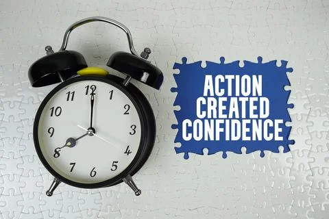 Action Created Confidence text with alarm clock on navy blue background Stock Photos