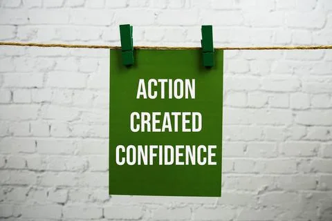 Action created confidence text on green paper card hanging with rope on whi.. Stock Photos