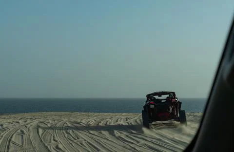 Action motion blur of a dune buggy driving along a soft focus coastal ridge Photos
