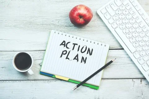 Action plan text on notebook with keyboard and coffee on table Stock Photos