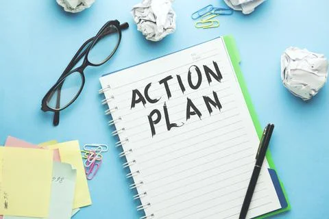 Action plan text on notebook with stationary Stock Photos