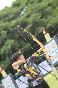 Action shot of an archery athlete pulling the bowstring and aiming Stock Photos
