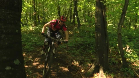 Action shot of two downhill cyclists passing by in the woods Stock Footage 55912701