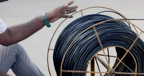 Action of a worker is rolling the electrical wire cable into the reel. Stock Footage 236889890