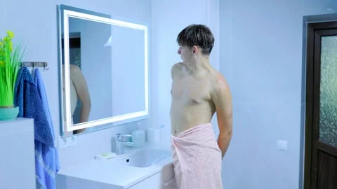 Active adolescent youth flexing biceps muscles reflecting bathroom mirror. Stock Footage 345531645
