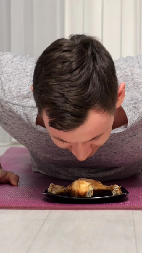 Active Adult Does Floor Pushups Directly Above Cooked Chicken Dish. Dedicated 스톡 동영상 346989786