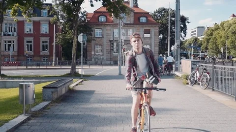 Active and athletic young man on a bicycle and with a skateboard in his hands Stock-Footage 81927075
