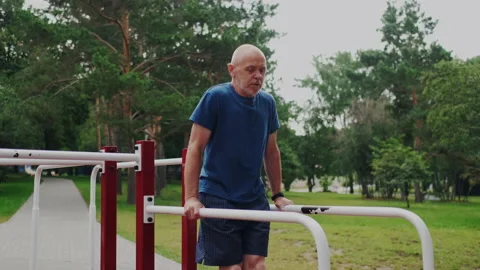 Active and Powerful Old Man Workout on Sports Playground with Gym Equipment. He Stock Footage 148468727