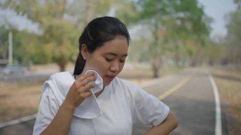 An active Asian female runner taking a break to catch her breath Stock Footage 274462328