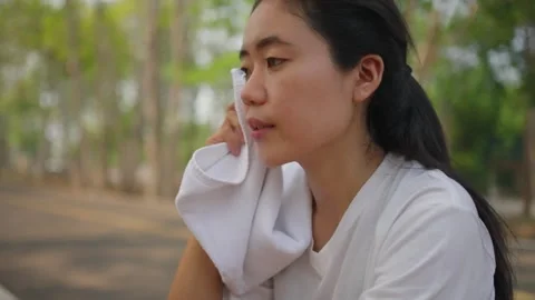 An active Asian female runner taking a break to catch her breath Stock Footage 274469195