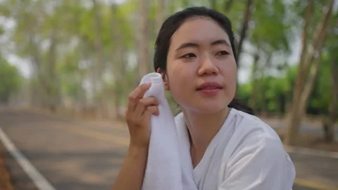 An active Asian female runner taking a break to catch her breath Stock Footage 274469285
