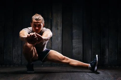 Active athlete do exercises on the floor, intense training on black backgroun 스톡 사진