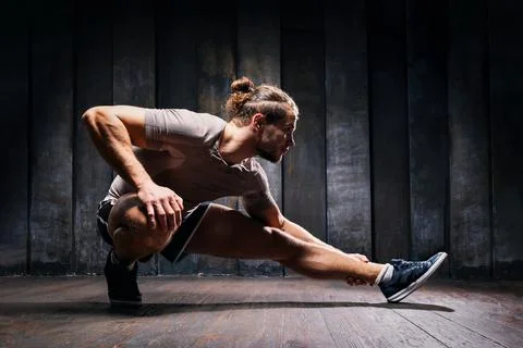Active athlete do exercises on the floor, intense training on black backgroun Stock Photos