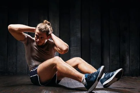 Active athlete do exercises on the floor, intense training on black backgroun 스톡 사진