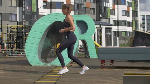 Active athletic girl doing leg warm up exercises on asphalt Stock-Footage 140364156