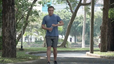 Active athletic young man runner jogging in park. Fit male sport fitness Stock Footage 74826545