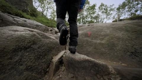 Active backpacker man fast climbing on wet stones mountain walking at rainforest Stock Footage 153982080
