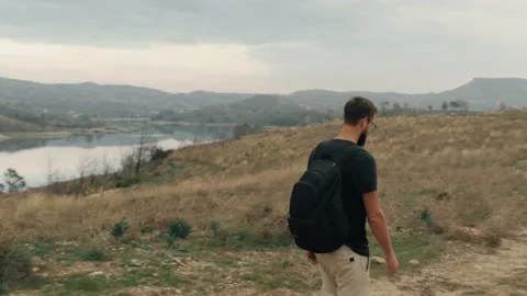 Active backpacker man walking at autumn hilly terrain natural canyon park Stock Footage 234620536