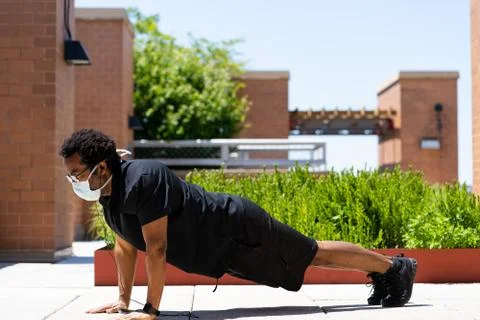 Active black man does pushups in protective mask during covid-19 quarantine Free Stock Photos