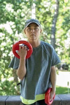 Active blonde female doing strength training with weights outdoors Stock Photos