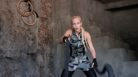 Active blonde lady does intense training with battling ropes Stock Footage 207397712