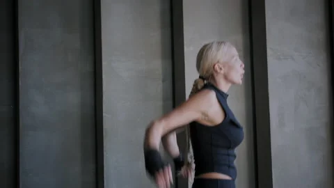 Active blonde woman jumps making circles with hands in gym Stock Footage 207405053