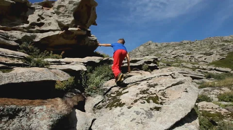 Active boy climbing on the top of the mountain Stock Footage 65829189
