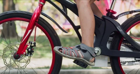 Active boy engages in riding bicycle in lively city park Stockbeeldmateriaal 273781121