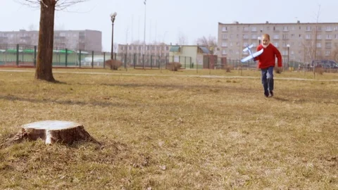 Active boy jumping and throwing toy plane Stock Footage 127621281