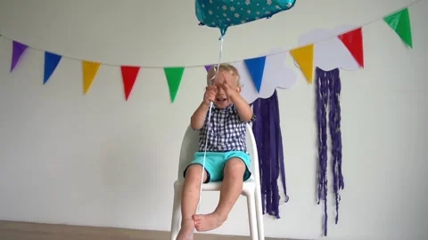 Active boy playing with balloon after second birthday party. Gimbal slow motion Stock Footage 136079011