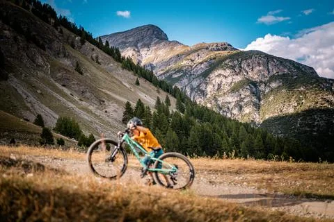 Active boy pushs up his bicycle. Little rider with mountain bike. Enduro riding Stock Photos