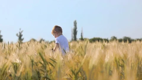 Active boy puts black hat on and takes off on yellow field Stock Footage 112337996
