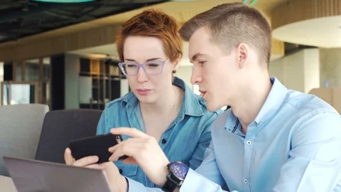 Active brainstorm of two young hardworking managers with laptop and mobile Vídeos de archivo 73301695