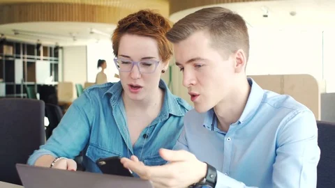 Active brainstorm of two young hardworking managers with laptop and mobile Vídeos de archivo 73302593