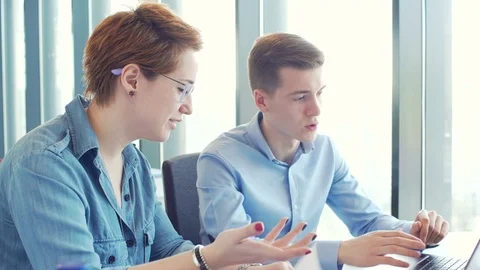 Active brainstorm of two young hardworking managers with laptop and mobile Vídeos de archivo 73303618