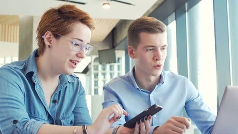 Active brainstorm of two young hardworking managers with laptop and mobile Stock Footage 73305449