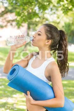 Active calm brunette holding exercise mat Stock Photos