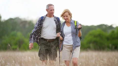 Active Caucasian American seniors training with Nordic walking sticks to keep Stock Footage
