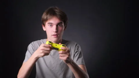 Active Caucasian Man Gaming with Controller on black Background Stock Footage 257458499