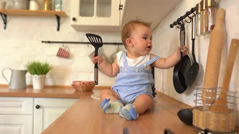 Active child boy playing on the table in the kitchen Stock Footage 135882546
