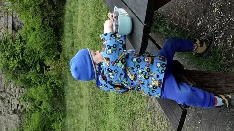 An active child eats organic food from a thermos in nature Stock Footage 239921951