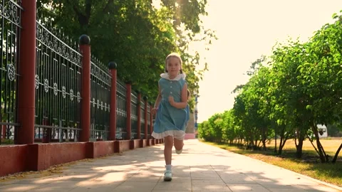 Active child playing in spring park. Kid run. Little happy girl smiles running Stock Footage 304288176