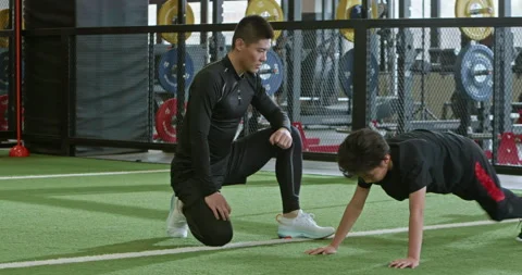 Active Chinese boy having exercise class with coach in gym,4K Stock Footage 156632212